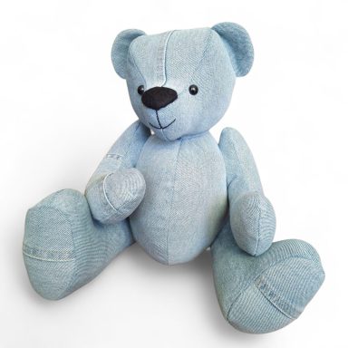 Een schattige blauwe teddybeer met een zwarte neus, zittend met open armpjes.