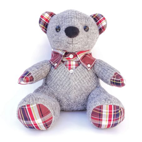 Grijze knuffelbeer met gestreepte kraag en plintermotief op de poten.